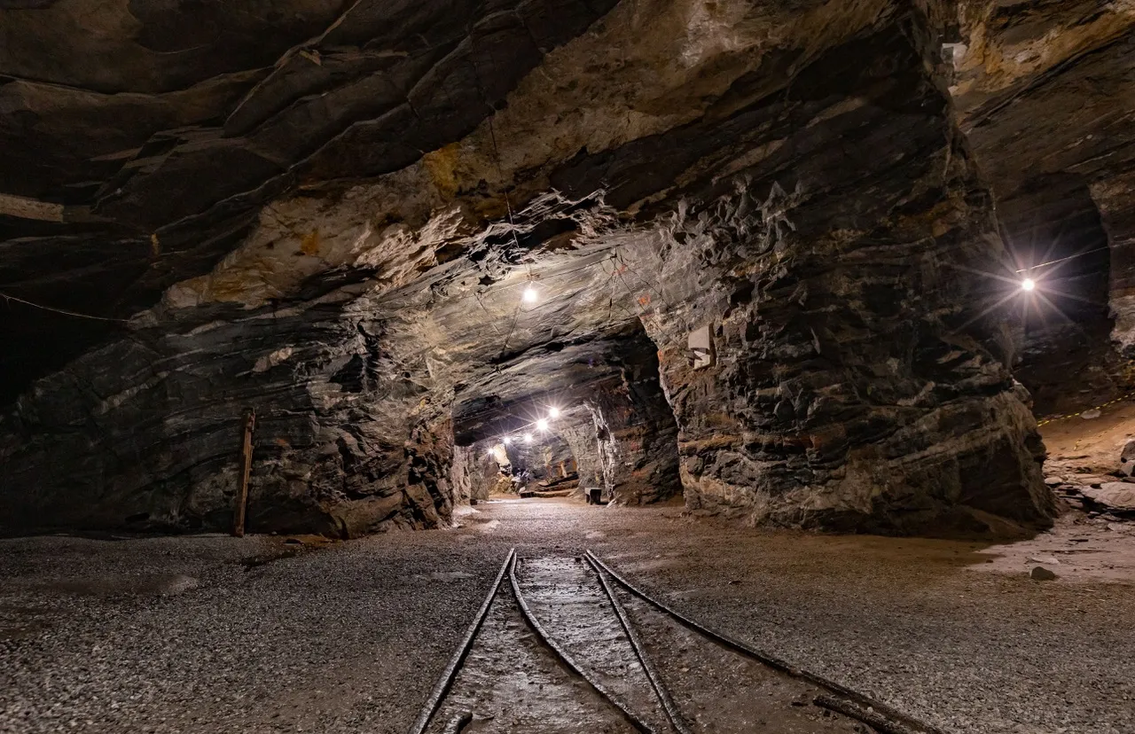 An underground mine drift with rails along its floor